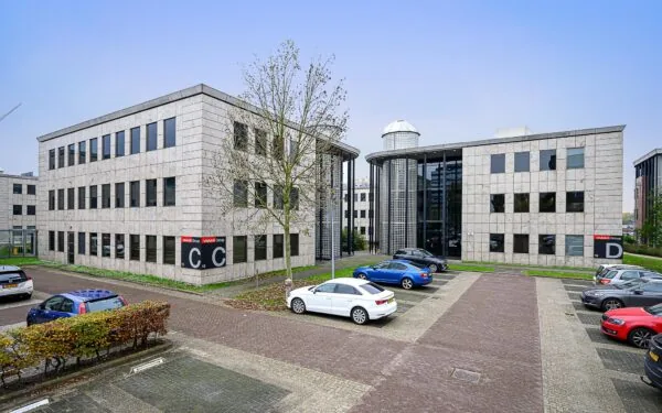 Kantoorgebouwen C en D aan de Rivium Westlaan met parkeerplaatsen op de voorgrond.